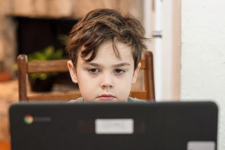 Kind achter laptop